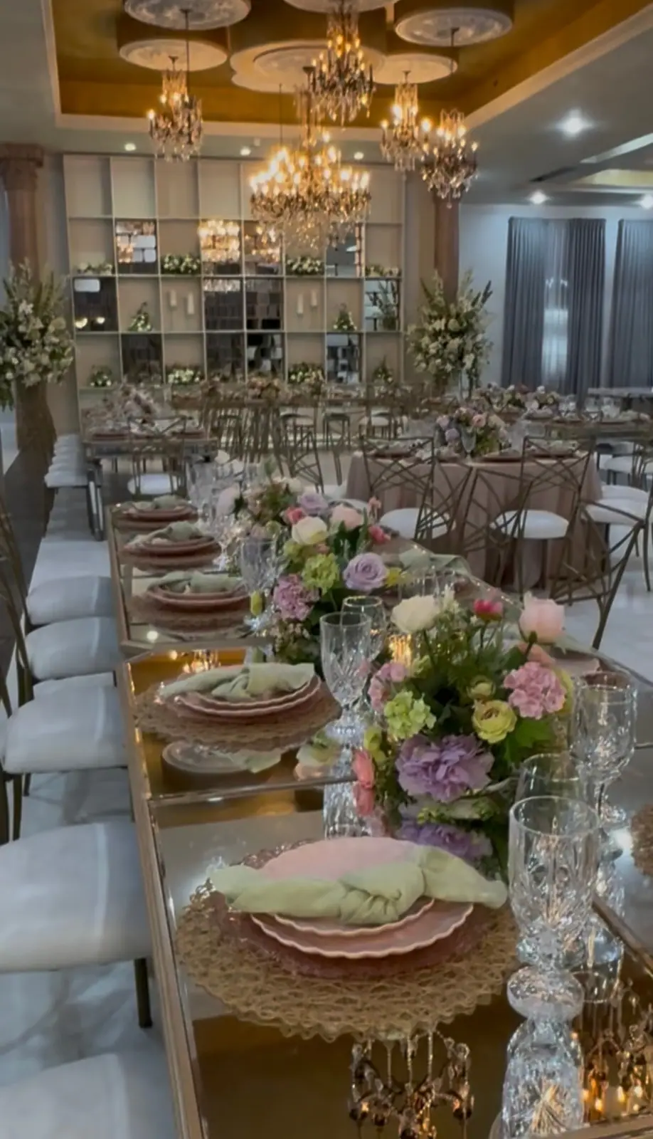 A long reception table set with pink florals and candles